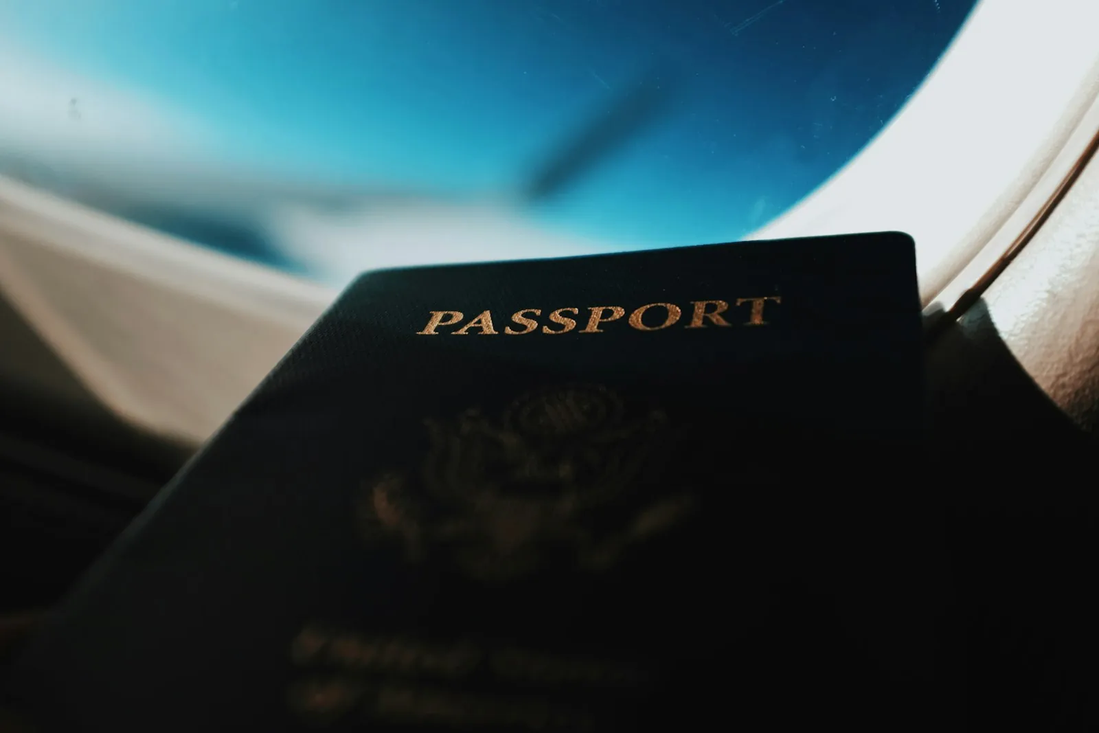 A passport in front of an airplane window